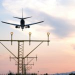 Aircraft during the approach procedure at sunset overflying the