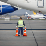 Man for an airport staff on the runway between commercial airpla