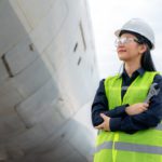 Asian woman engineer maintenance airplane arm crossed and holdin