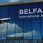 Airplane landing at Belfast Ireland airport mirrored in terminal