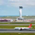 Istanbul, Turkey - June 3, 2023: Turkish Airlines airplane with Air Traffic Control Tower of Istanbul Airport. View of international Istanbul New Airport.