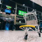 Empty abandoned luggage cart trolley in closed airport gate hall due to Coronavirus global COVID 19 outbreak