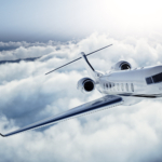 Realistic photo of White Luxury generic design private jet flying over the earth. Empty blue sky with white clouds at background. Business Travel Concept. Horizontal. 3d rendering