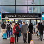 Passengers with luggage arriving at London Heathrow Airport Terminal 2.