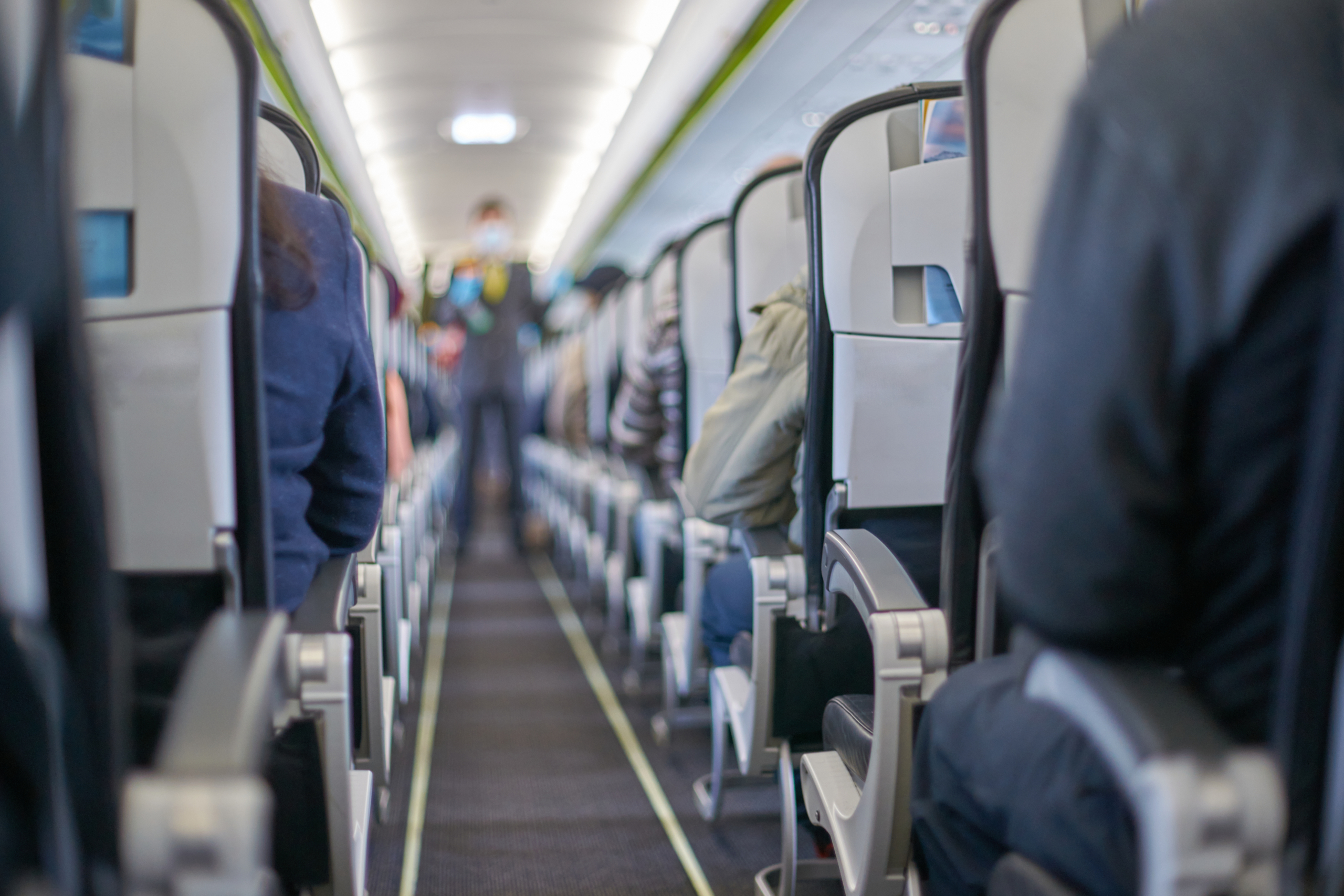 Passengers seated inside an aircraft cabin during flight.