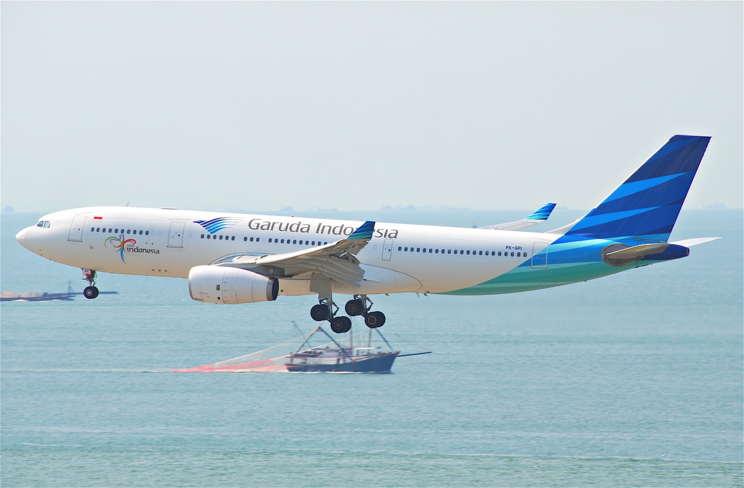 Garuda Indonesia aircraft flying over sea