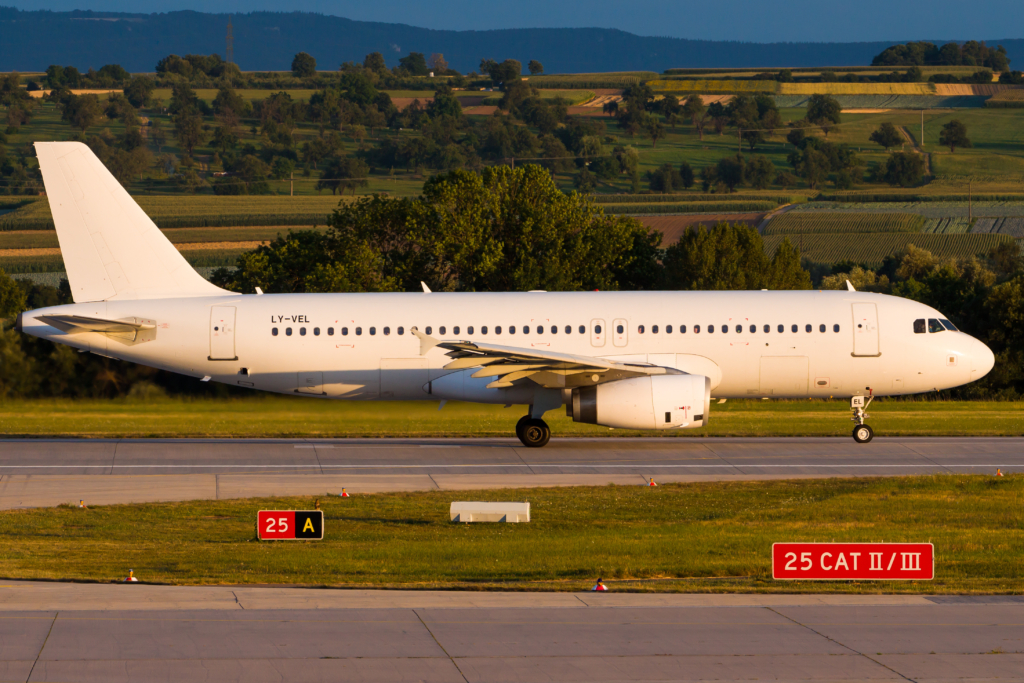 White Airbus A320 aircraft landing on a runway.