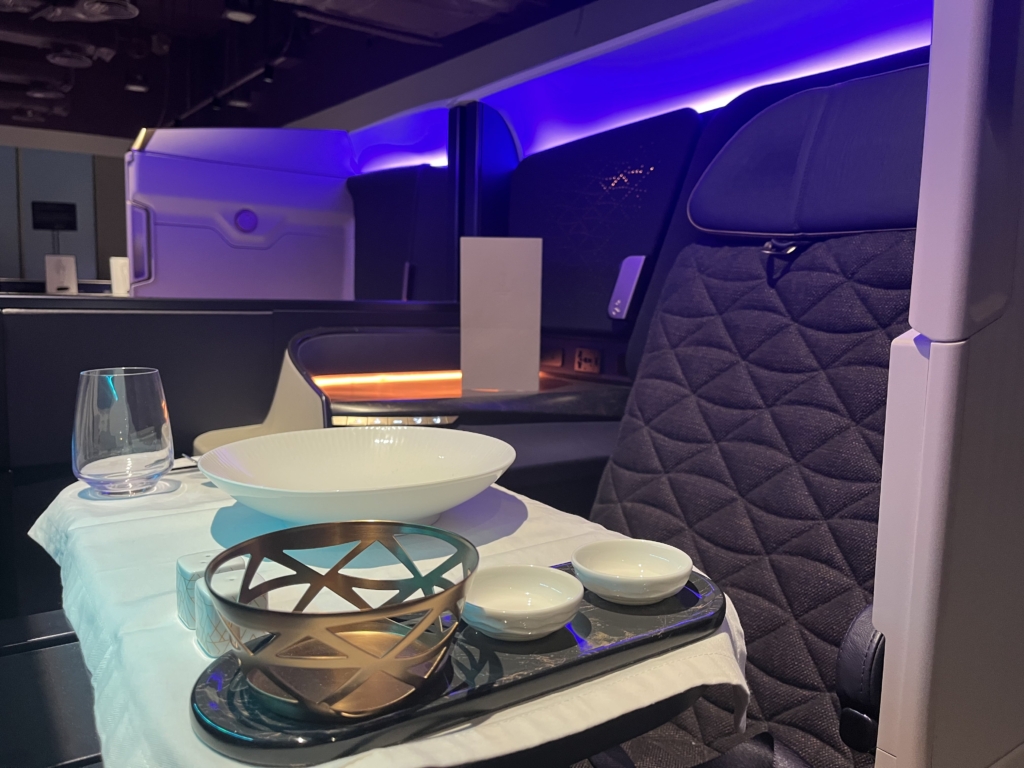 Riyadh Air business class seat with cutlery and plates.