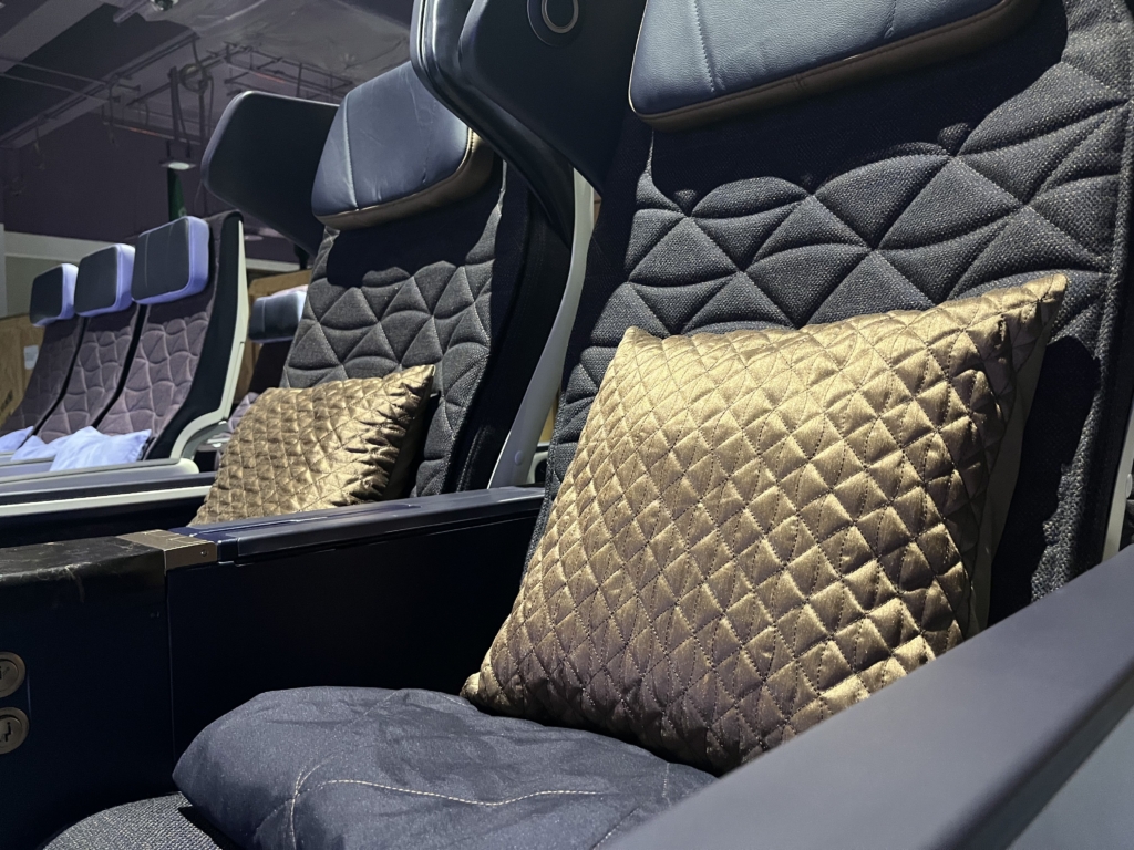 Riyadh Air's premium economy seat with a pillow on it and the economy class in the background.
