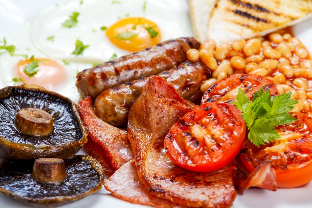 Full English breakfast with bacon, sausage, fried egg, baked beans and mushrooms.
