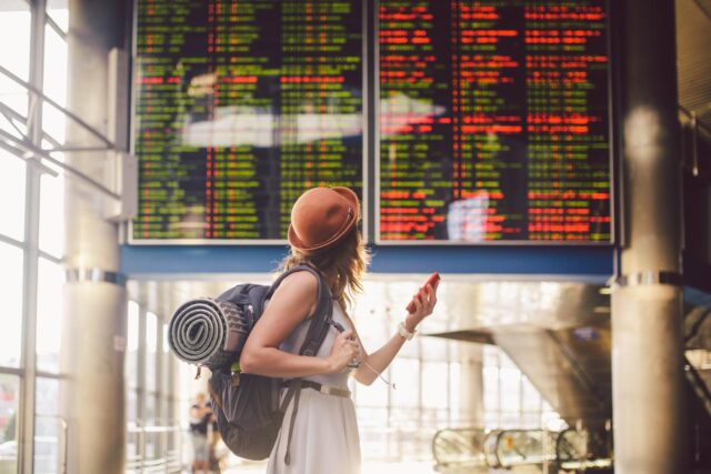 passenger checks flight display at airport terminal