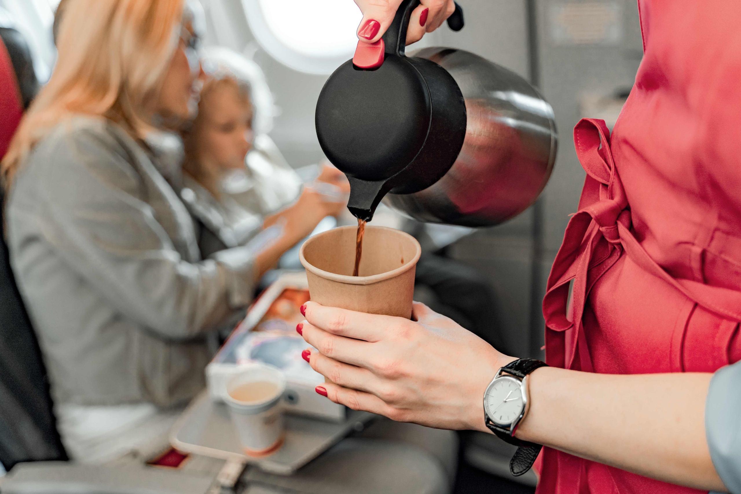 Cabin crew serving coffee on a flight