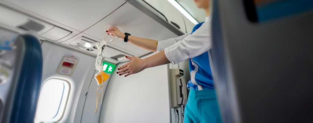 Aeroflot shows how to use an oxygen mask on board, Air hostess demonstrate safety procedures to passengers prior before airplane flight take-off