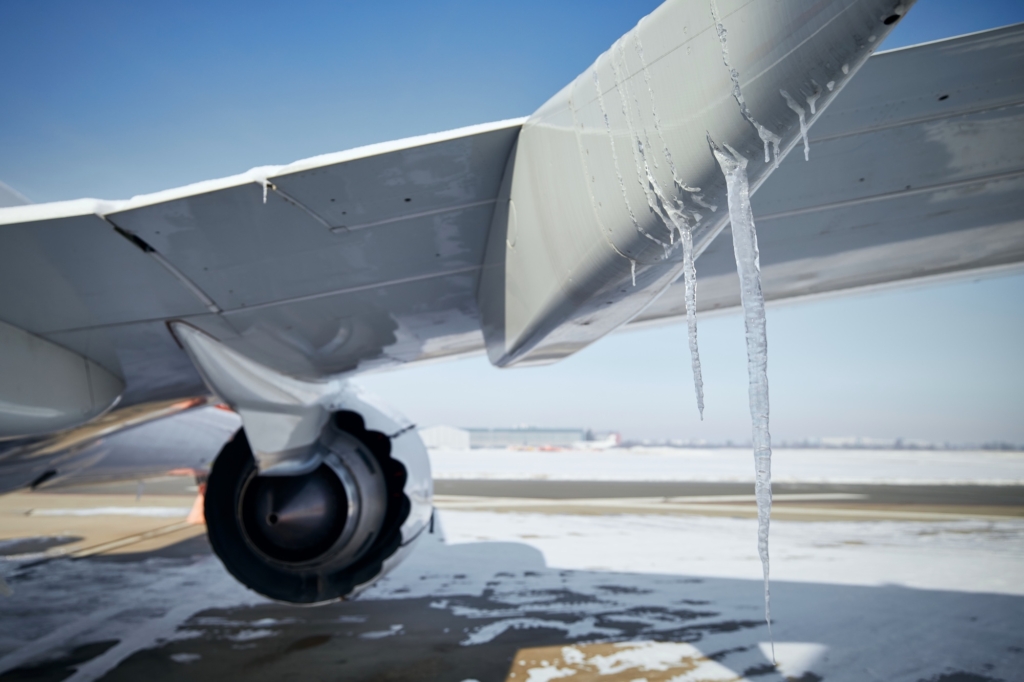 Selective focus on icicles hanging from airplane in frosty day.