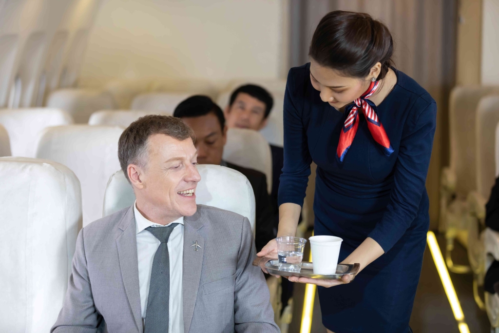 Cabin crew serving coffee and water on an airline flight