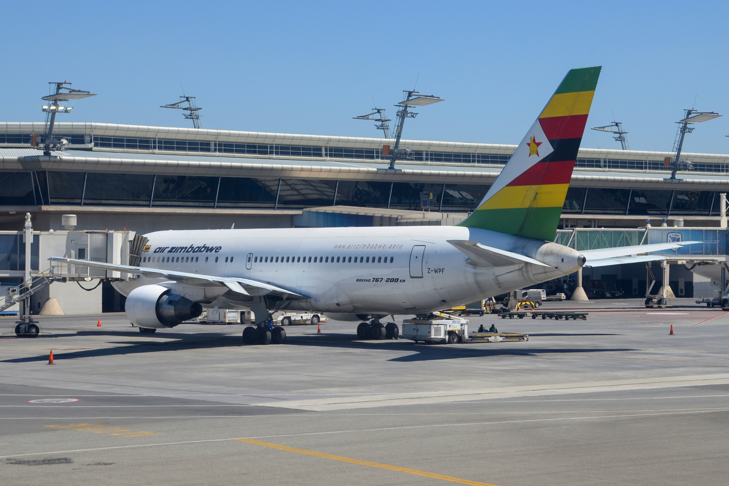 Air Zimbabwe Boeing 767 parked at the gate.