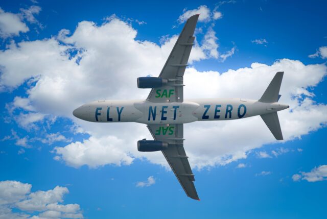 Aircraft soars through the sky with a prominent 'SAF' and 'Fly Net Zero' label on it. Experience the future of carbon-neutral flying and the positive impact of renewable aviation fuel or SAF