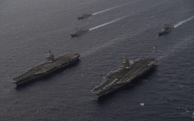 Two of the US Navy's Nimitz-class warships - comprising the USS Theodore Roosevelt (CVN-71) and USS Nimitz (CVN-68) - sail together during a drill in the South China Sea on 9 February 2021. Image: US Navy/Mass Communication Specialist 3rd Class Elliot Schaudt
