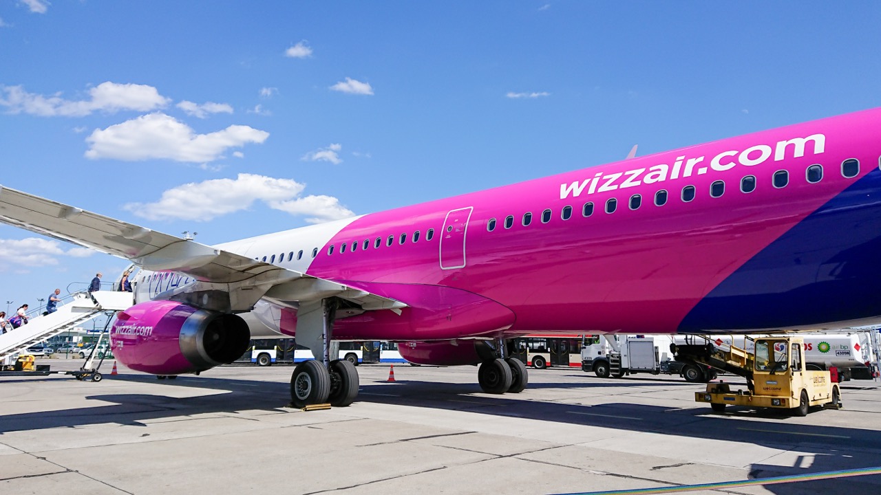Gdansk, Poland. June 09, 2019. Wizz Air aircraft during passenger boarding on airport apron with ground service vehicles and terminal building in background.
