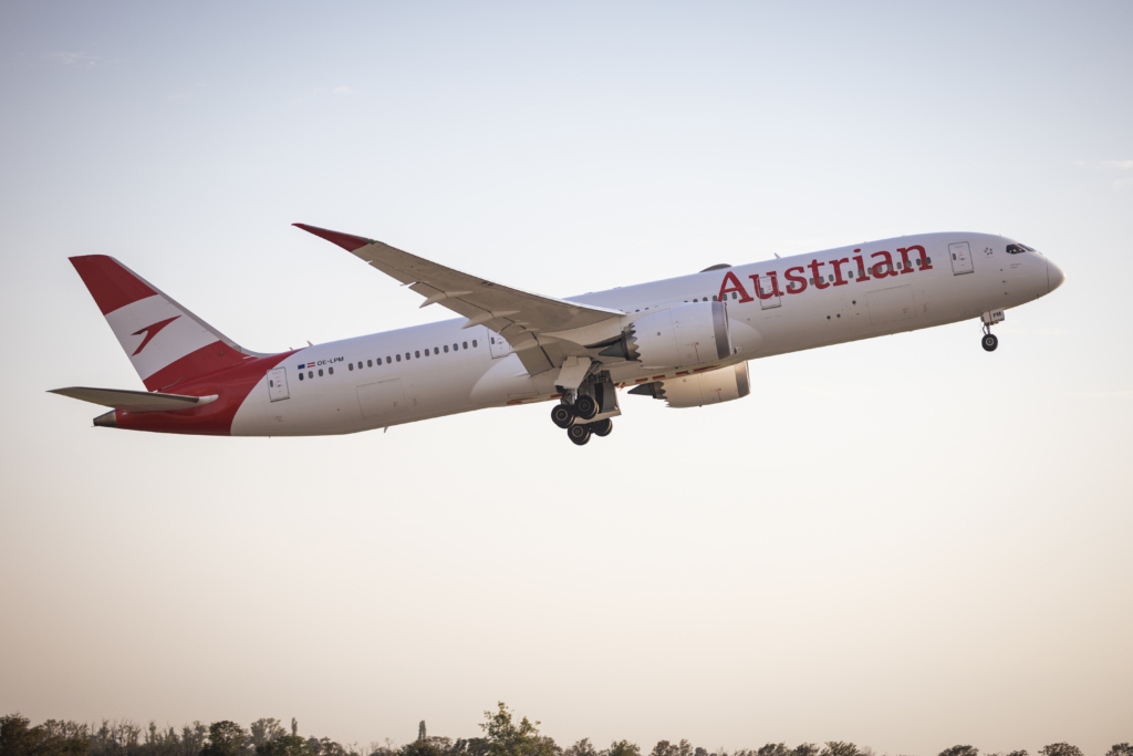Austrian Airlines Boeing 787 aircraft taking off in the sunset.