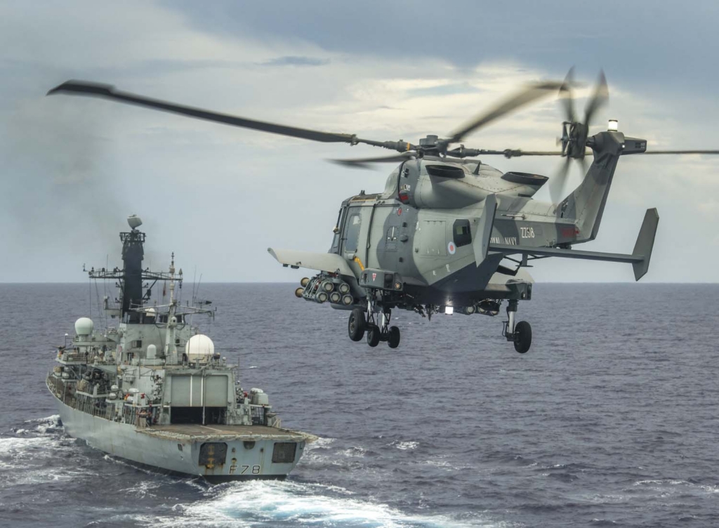 HMS Defender's Wildcat HMA Mk 2 helicopter conducts a fly past HMS Kent with her Martlet wings attached whilst in the Indo-Pacific region.