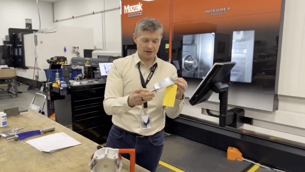 Blake Scholl holds a turbine blade at Boom's superfactory