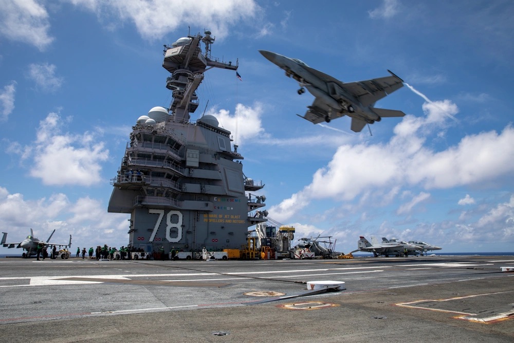 USS Gerald R. Ford with fighter jet launching from the deck
