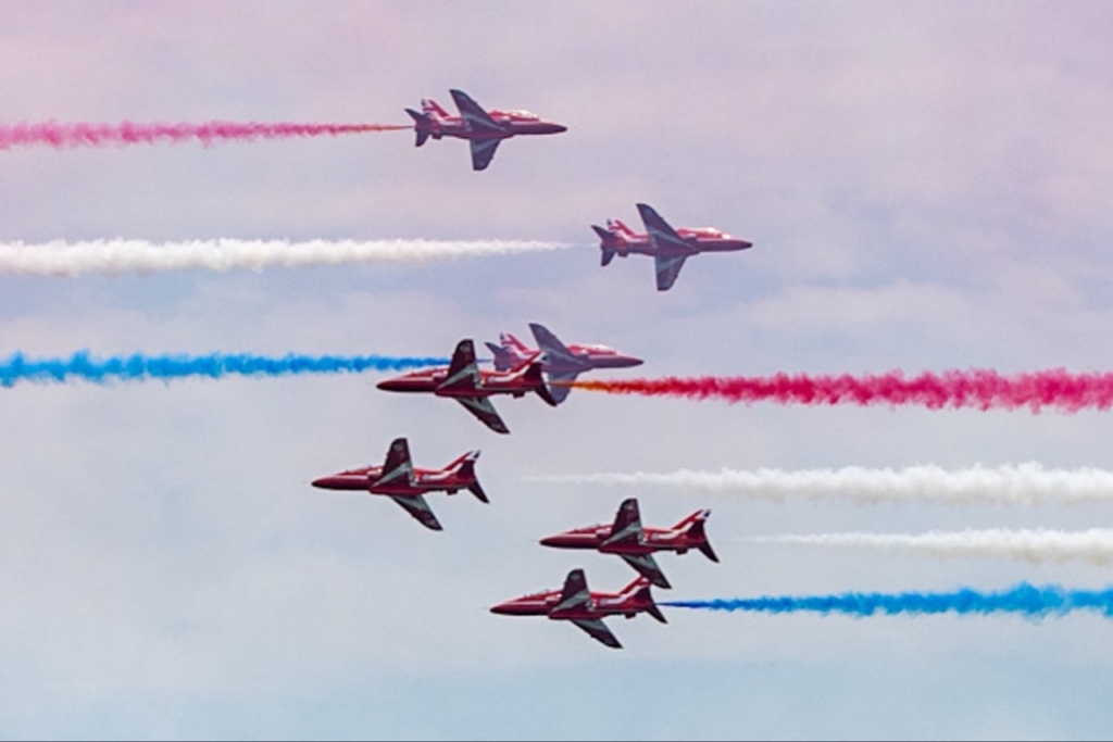 The Royal Air Force Aerobatic Team, The Red Arrows fly down the Hudson river in New York streaming the Red, White and Blue. 