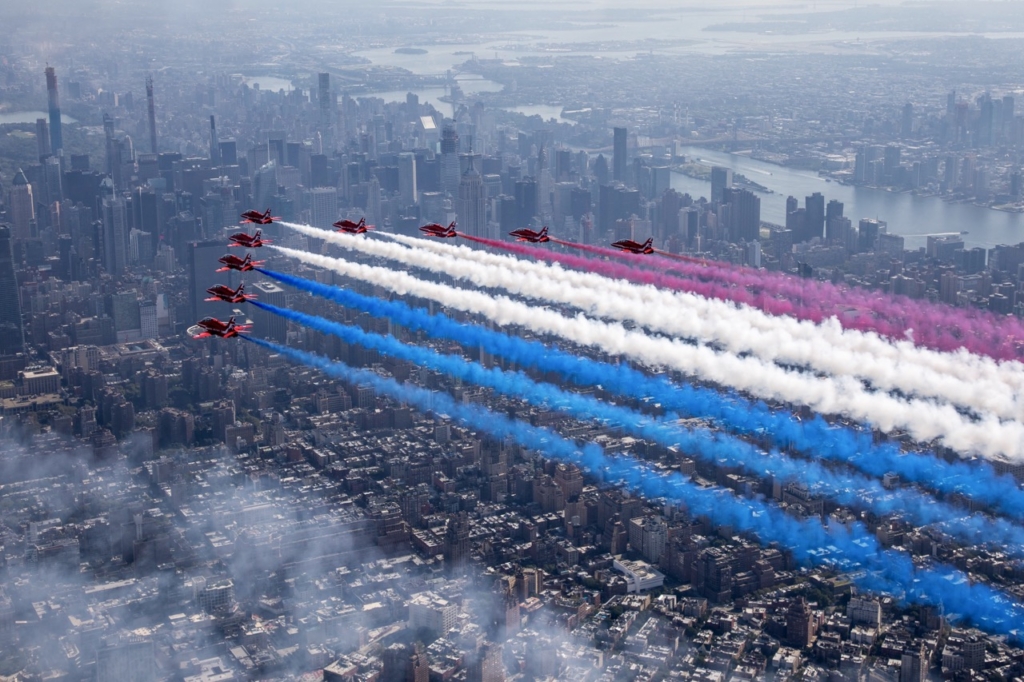The Royal Air Force Aerobatic Team, The Red Arrows fly down the Hudson river in New York streaming the Red, White and Blue. 