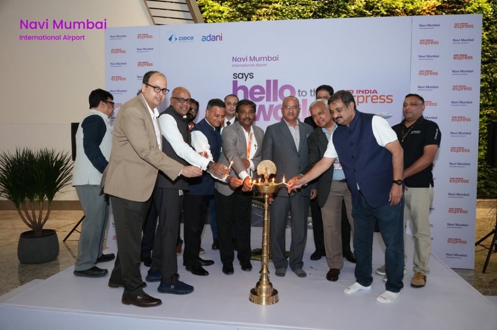 Workers celebrate the first international flight from Navi Mumbai