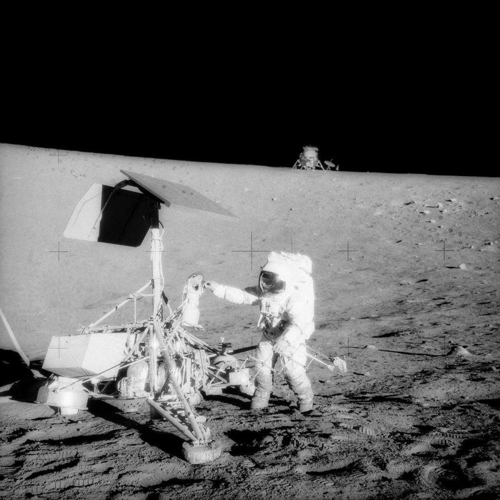 A photograph taken during Apollo 12’s second extravehicular activity (EVA) capturing two U.S. spacecraft on the lunar surface: the unmanned Surveyor 3 in the foreground and the Apollo 12 Lunar Module (LM) in the background.