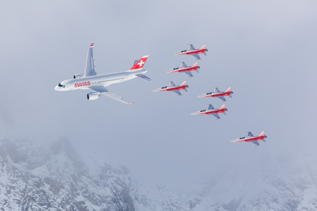 A SWISS-operated Airbus A220-100 (registration ZB-JBB) flies alongside the Swiss Air Force's Patrouille Suisse display team in December 2021. Image: Swiss International Air Lines Ltd