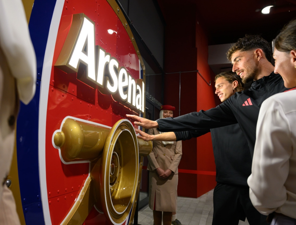 Arsenal players touch the new crest from Emirates