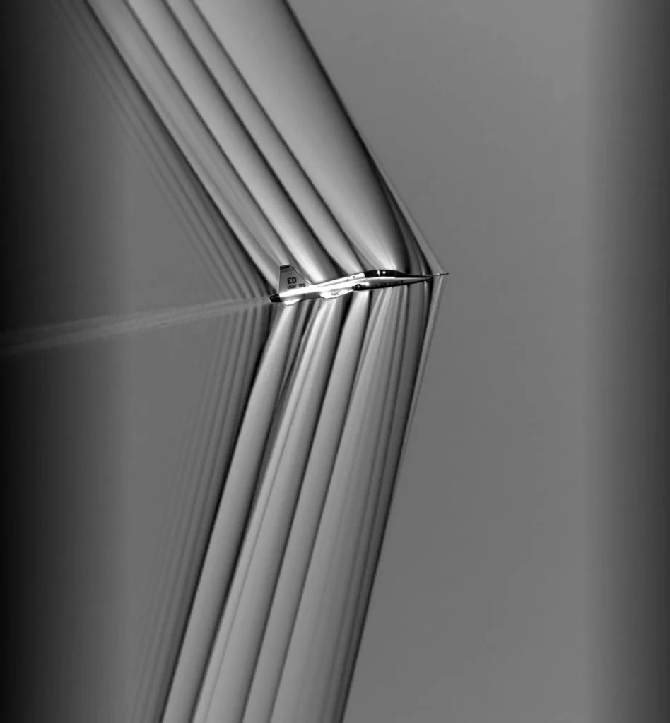Shock waves are visible around a T-38 trainer aircraft during NASA’s Air-to-Air Background Oriented Schlieren flights in 2019. Schlieren imaging makes normally invisible changes in air density visible, giving researchers a way to see the same shock waves that can create sonic booms on the ground. NASA Armstrong Flight Research Center used this work to refine airborne schlieren photography techniques in support of X-59 flight testing and NASA’s Quesst mission.