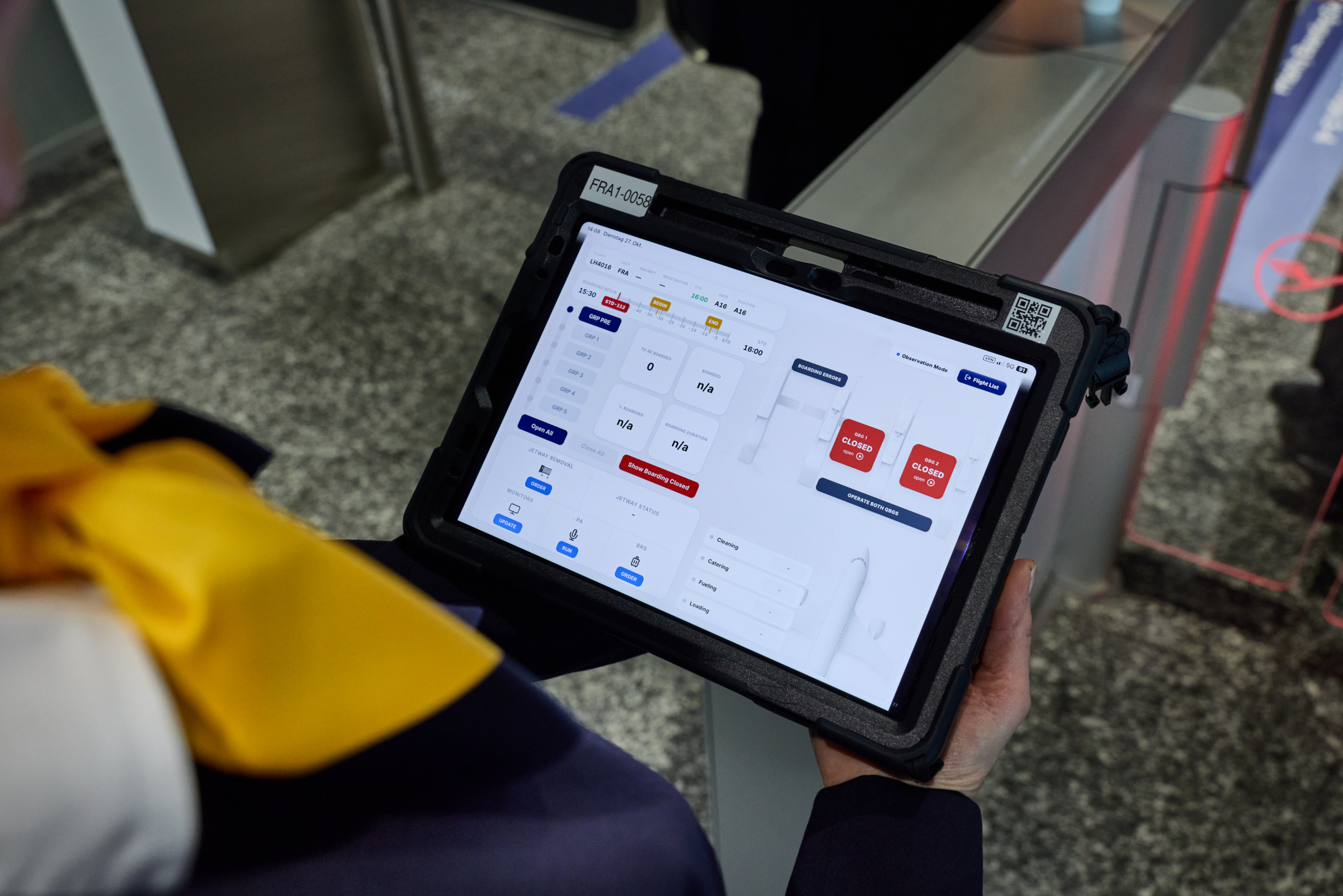 Boarding staff circulate at the gate with a tablet that provides access to various boarding systems