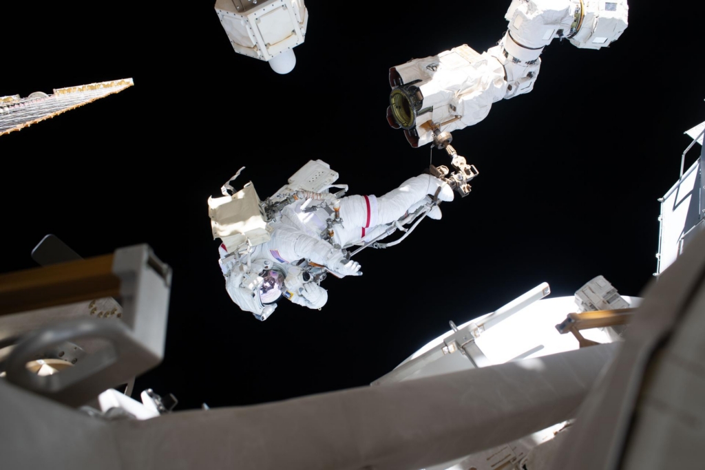 NASA astronaut Anil Menon is attached to the Canadarm2 robotic arm’s latching end effector during a spacewalk on Aug. 25, 2026, to install a high-speed space-to-ground antenna on the International Space Station.